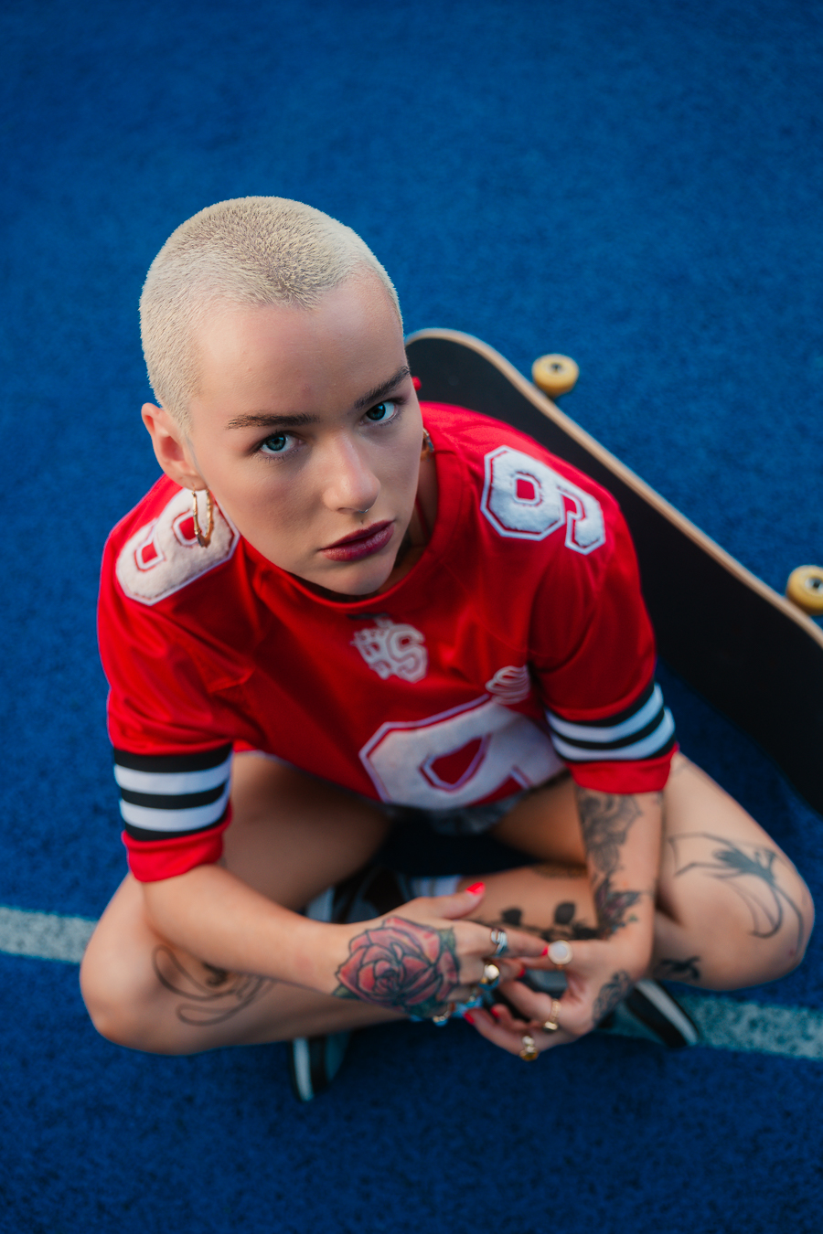 Close-up editorial portrait of model in red jersey on a blue pickleball court, Kilmarnock