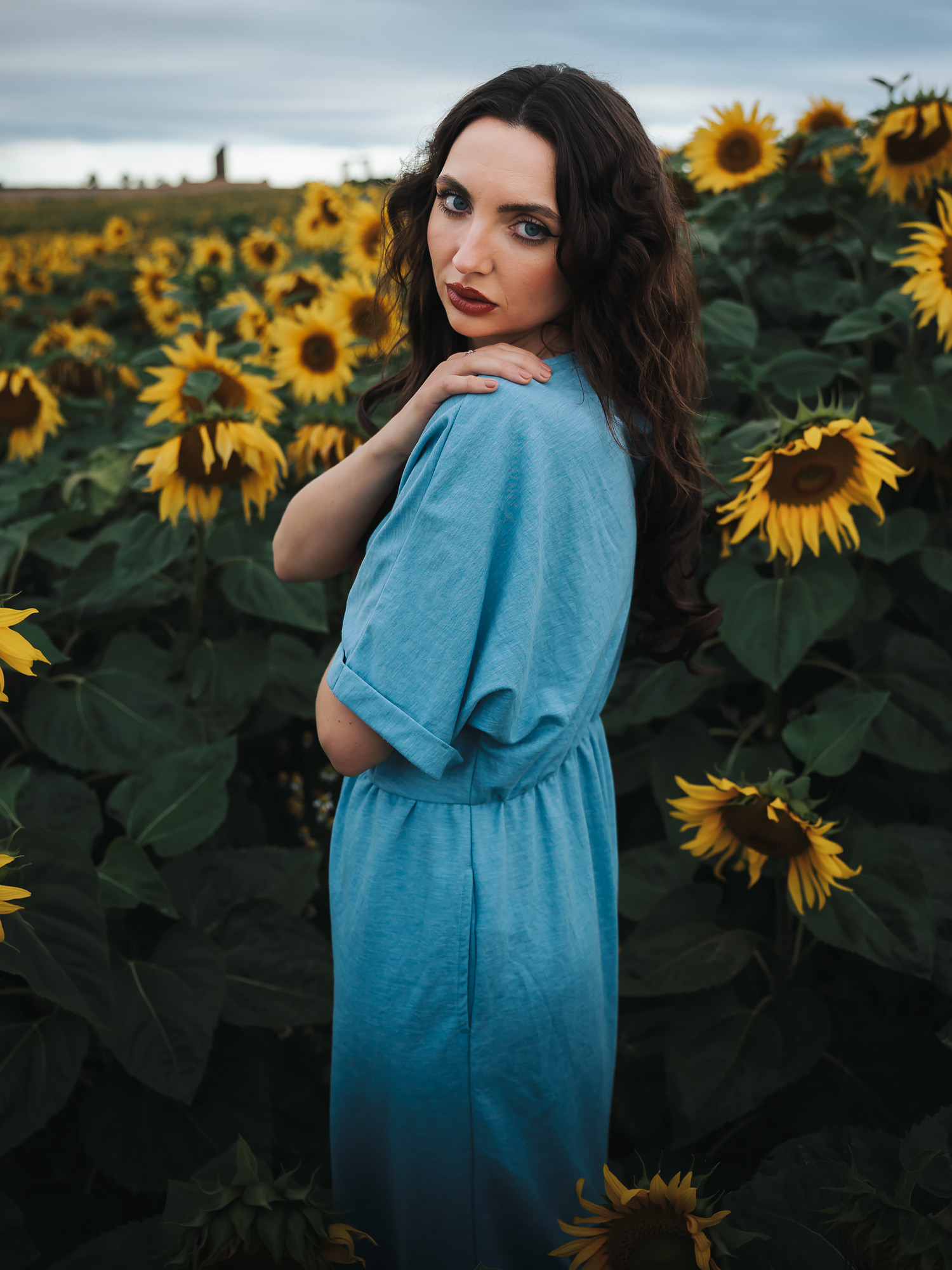 Close-up editorial portrait in a sunflower field near North Berwick, East Lothian, shot in early morning light