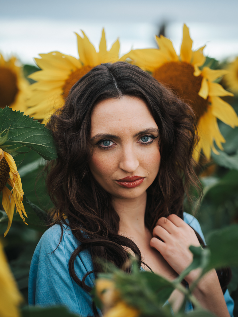 Backlit editorial portrait shot through sunflower petals at sunrise, East Lothian